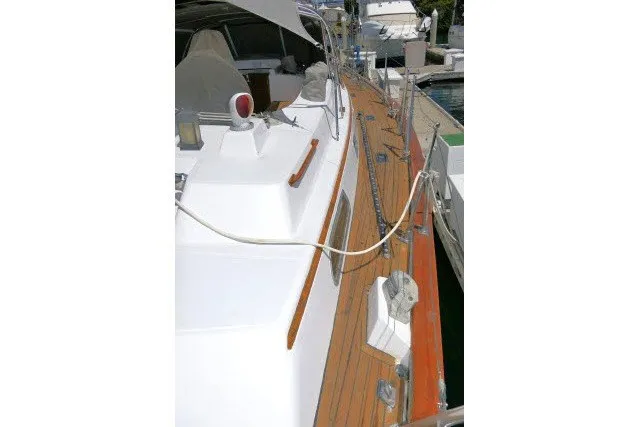 Slide: The Image of 1986 Tayana 52 Center Cockpit yacht with teak deck and white cabin, docked at marina. - 63