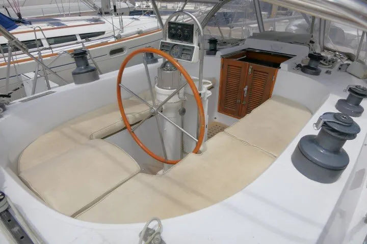 Slide: The Image of 1986 Tayana 52 Center Cockpit sailboat with wooden wheel and spacious seating area. - 57