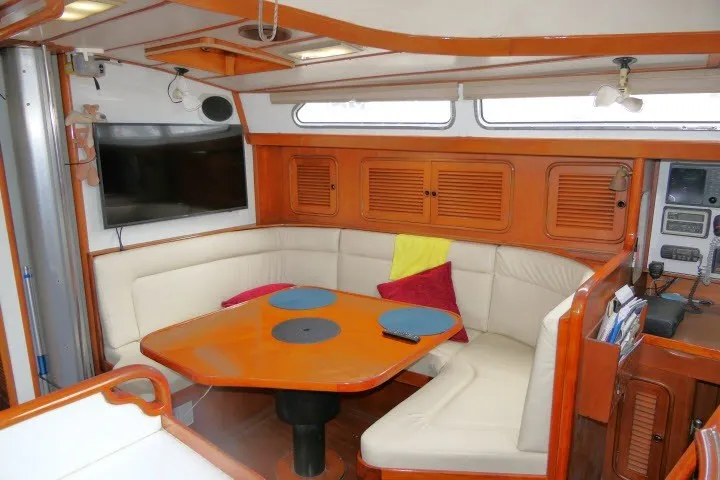 Slide: The Image of Interior of 1986 Tayana 52 Center Cockpit yacht with cozy seating and wooden accents. - 5