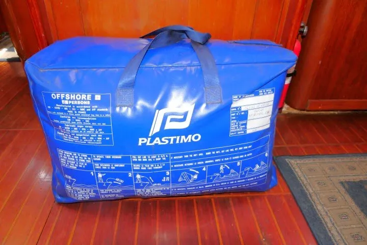Slide: The Image of Blue Plastimo offshore safety bag on Tayana 52 Center Cockpit, 1986 model, wooden floor background. - 86