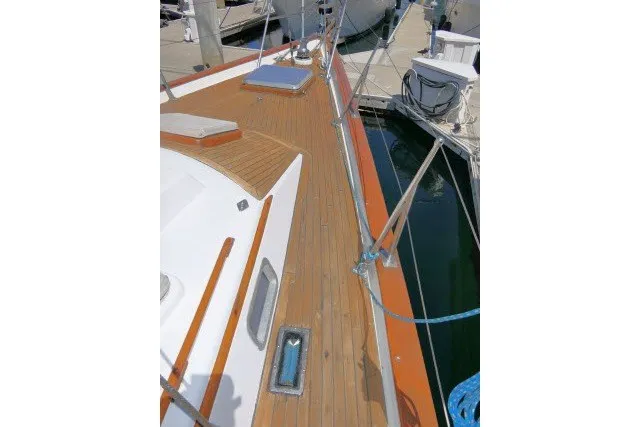Slide: The Image of 1986 Tayana 52 Center Cockpit sailboat deck with wooden finish at marina. - 64