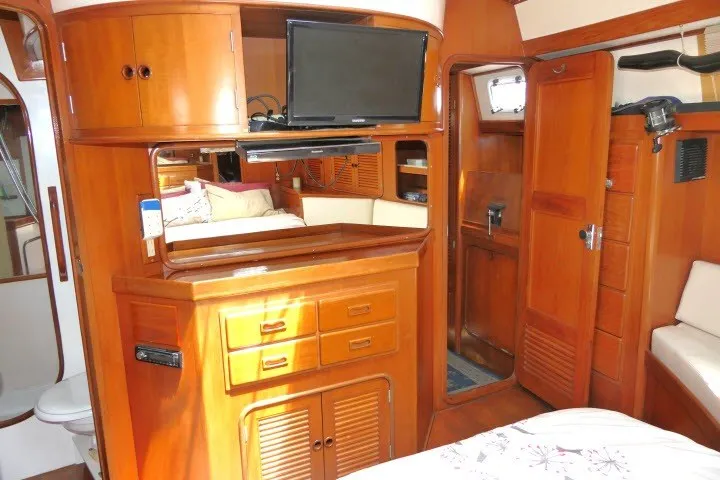 Slide: The Image of Interior of 1986 Tayana 52 Center Cockpit yacht with wooden cabinetry and cozy seating area. - 44
