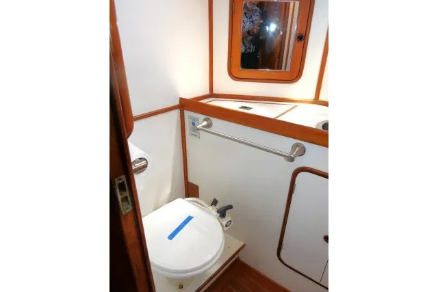 Slide: The Image of 1986 Tayana 52 Center Cockpit yacht bathroom with wooden accents and compact design. - 30