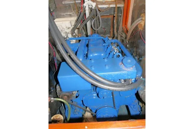 Slide: The Image of Engine of 1986 Tayana 52 Center Cockpit sailboat, painted blue, with visible hoses and wiring. - 80