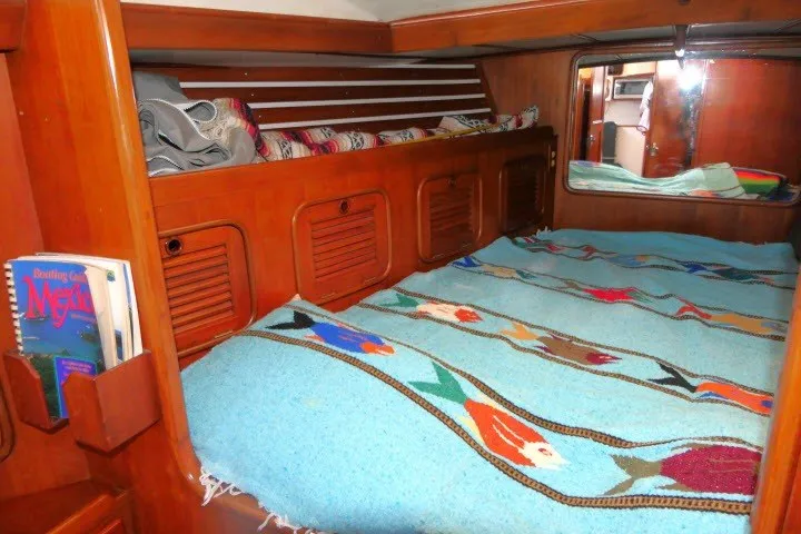 Slide: The Image of Cozy cabin interior of 1986 Tayana 52 Center Cockpit with colorful bedding and wooden storage. - 26