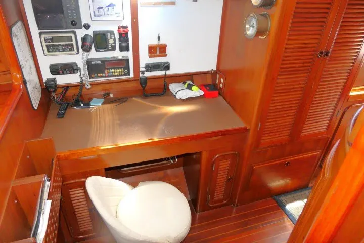 Slide: The Image of 1986 Tayana 52 Center Cockpit navigation station with wooden cabinetry and communication equipment. - 17