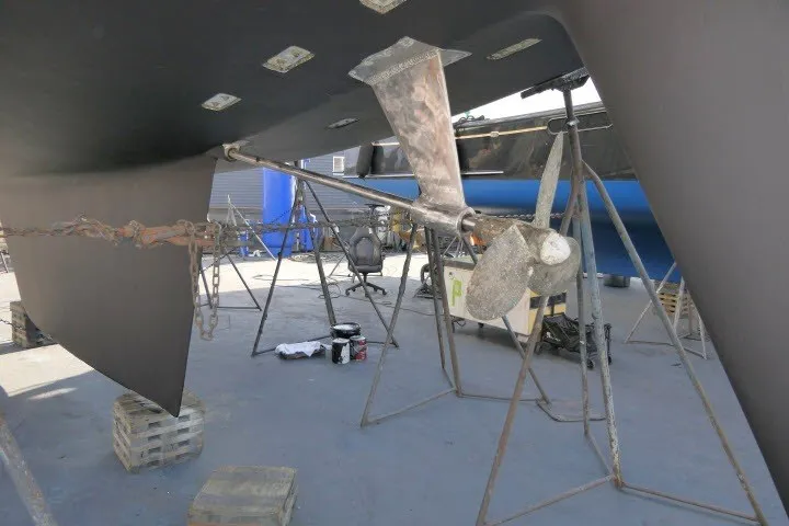 Slide: The Image of 1986 Tayana 52 Center Cockpit sailboat under maintenance, showing propeller and hull details. - 73