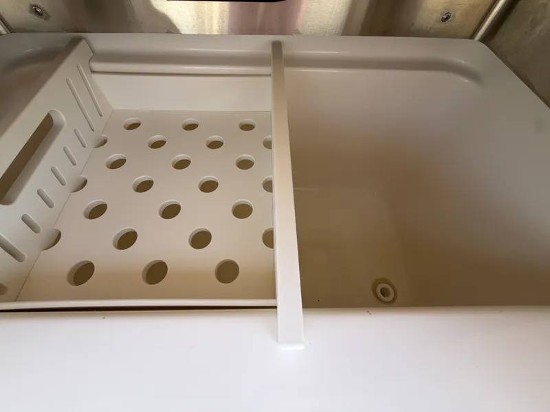 Slide: The Image of A white sink with a removable draining rack and a drain. - 33
