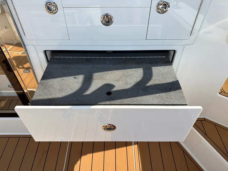 Slide: The Image of A drawer on a boat with a wood deck and shiny handles. - 30