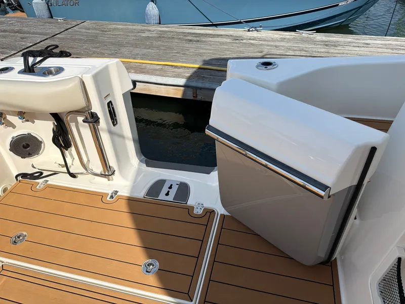 Slide: The Image of The image shows the cockpit of a 2024 Boston Whaler 405 Conquest with teak flooring and a door to the dock. - 26