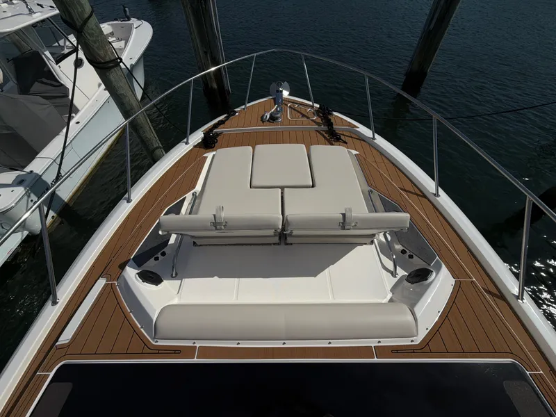 Slide: The Image of The bow of the 2024 Boston Whaler 405 Conquest features beige cushions and wood accents. - 38