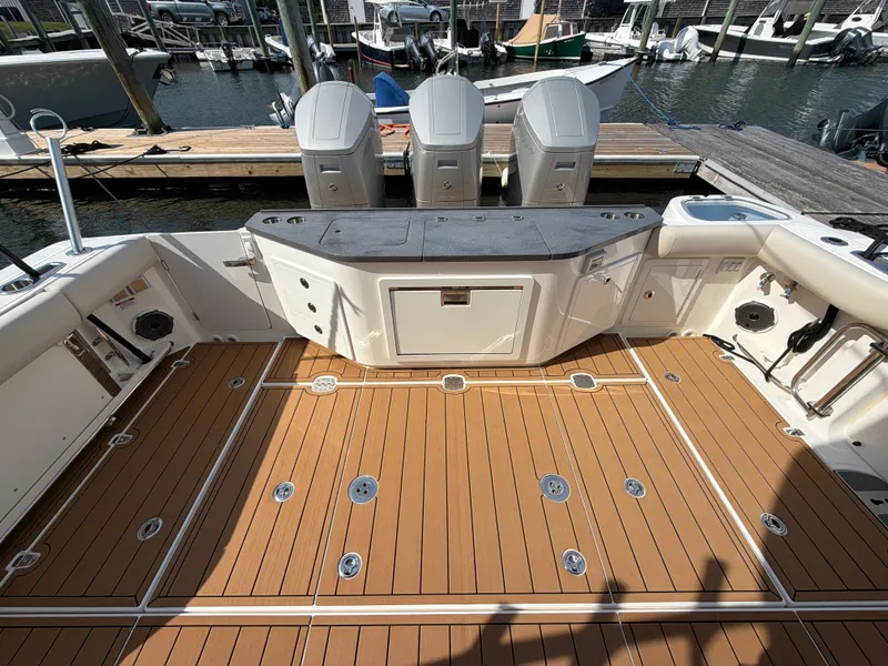 Slide: The Image of The image shows the cockpit of a 2024 Boston Whaler 405 Conquest with three outboard engines. - 20