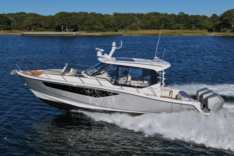 The Image of A sleek motorboat speeding across the water, featuring a modern design and three outboard engines. - 1