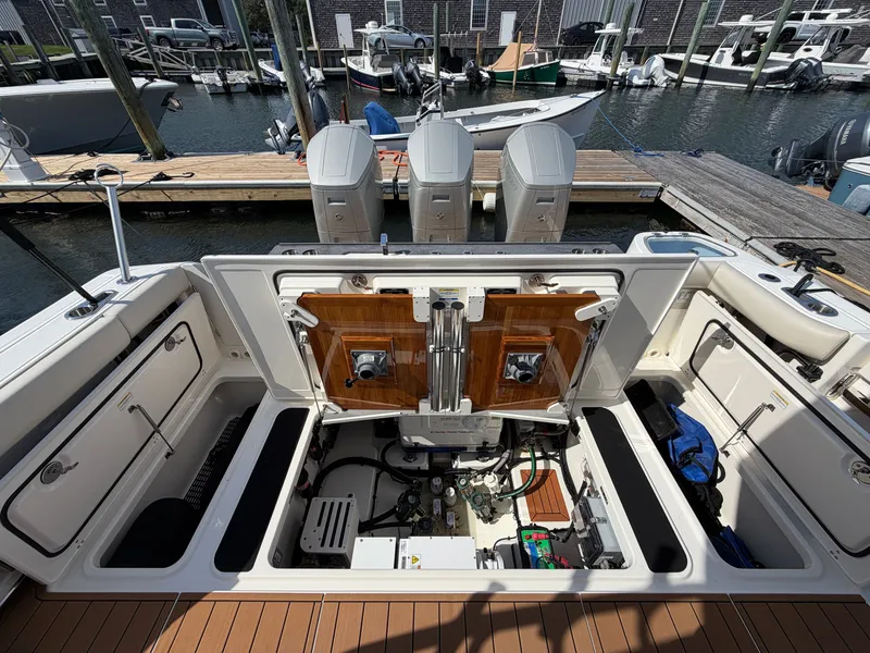 Slide: The Image of The image shows the engine compartment of a 2024 Boston Whaler 405 Conquest, docked at a marina. - 22