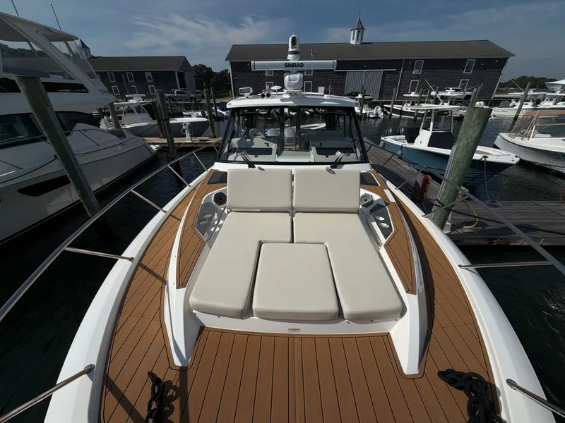 Slide: The Image of The image shows the foredeck of a 2024 Boston Whaler 405 Conquest with beige cushions. - 39