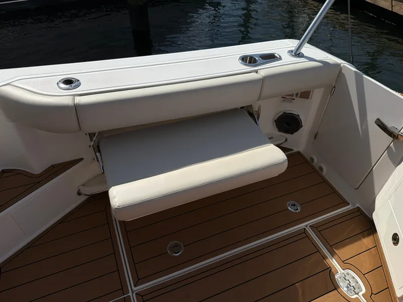 Slide: The Image of The 2024 Boston Whaler 405 Conquest features a sleek bench seat on a teak deck. - 27