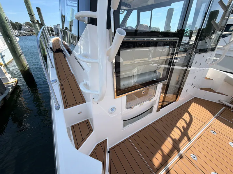 Slide: The Image of The image shows the deck of a 2024 Boston Whaler 405 Conquest with teak-style flooring. - 34