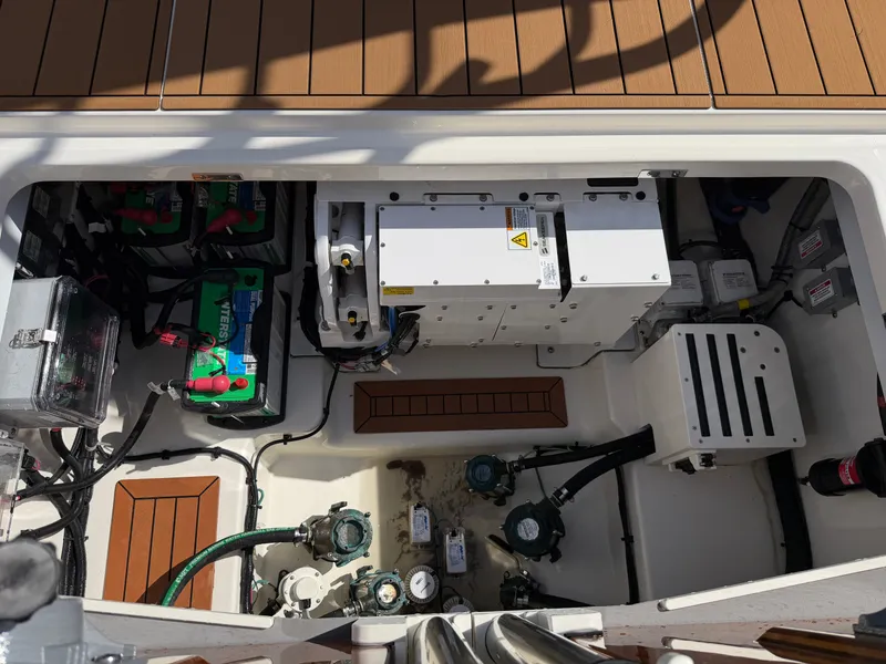 Slide: The Image of A view into the engine room of a 2024 Boston Whaler 405 Conquest with batteries and equipment. - 24