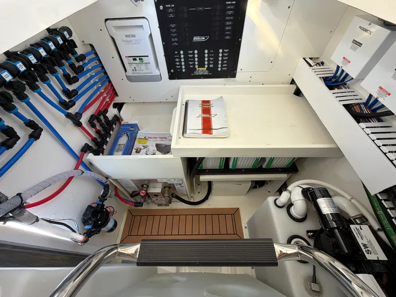 Slide: The Image of The utility room of a 2024 Boston Whaler 405 Conquest features organized wiring and control panels. - 46