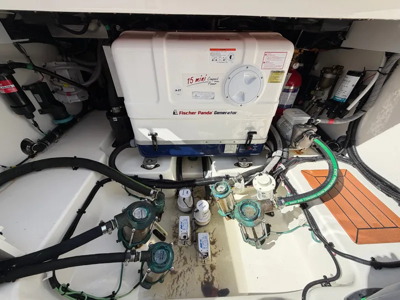 Slide: The Image of The engine room of a 2024 Boston Whaler 405 Conquest features a Fischer Panda generator and various valves. - 23