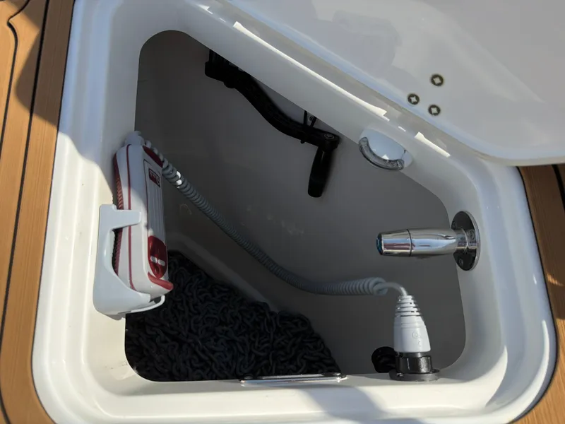 Slide: The Image of A storage compartment on a boat with a hose, nozzle, and rope. - 43
