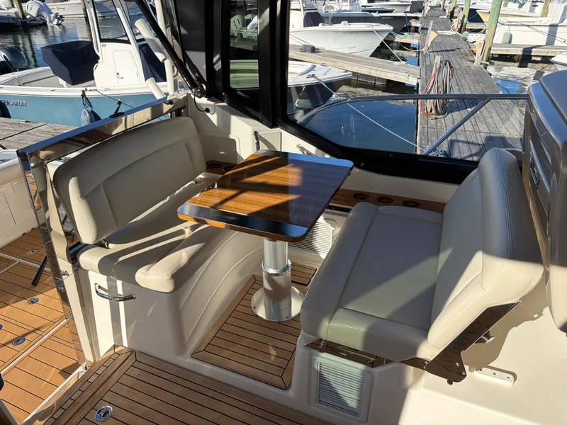 Slide: The Image of The seating area on a boat with a wooden table and cushioned seats. - 47