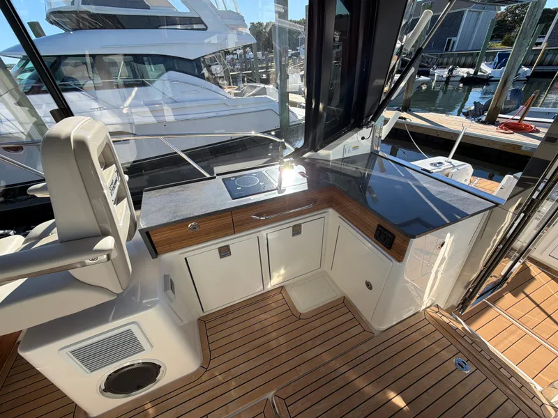 Slide: The Image of The 2024 Boston Whaler 405 Conquest features a modern galley with wood flooring and sleek countertops. - 49