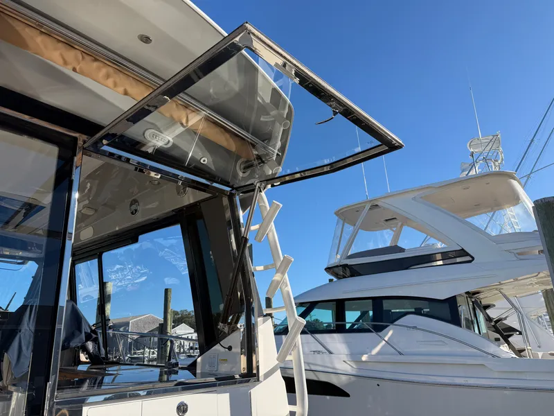 Slide: The Image of The 2024 Boston Whaler 405 Conquest features an open glass door and a ladder. - 36