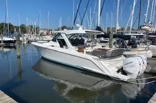 Slide: The Image of 2021 Tiara Sport 38 LS boat docked at a marina with clear blue skies. - 1