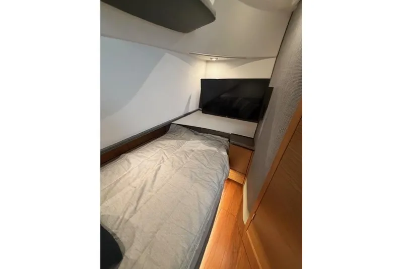 Slide: The Image of 2021 Tiara Sport 38 LS cabin interior with bed and TV, featuring modern design. - 24