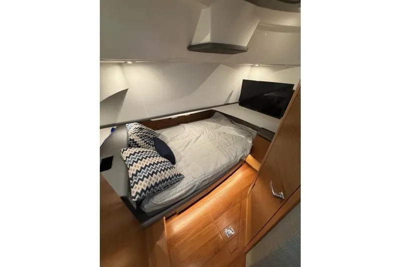 Slide: The Image of 2021 Tiara Sport 38 LS cabin interior with bed, pillows, and TV. - 25