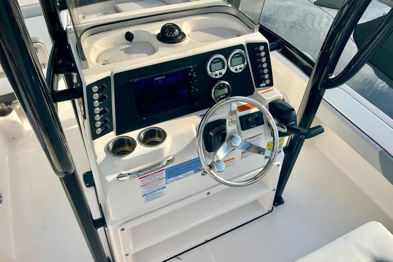 Slide: The Image of 2025 Robalo 226 Cayman boat dashboard with steering wheel and navigation controls. - 8