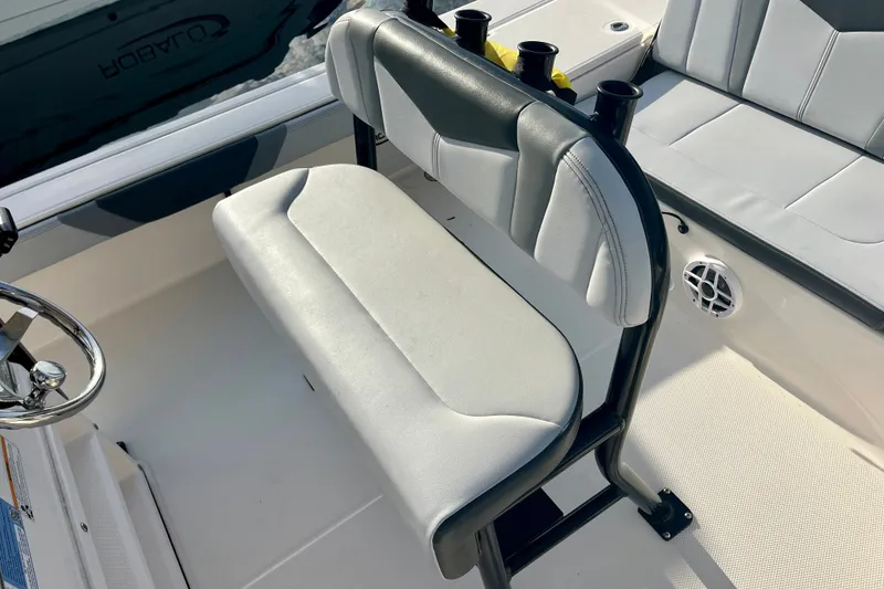 Slide: The Image of 2025 Robalo 226 Cayman boat interior with cushioned seating and steering wheel. - 7