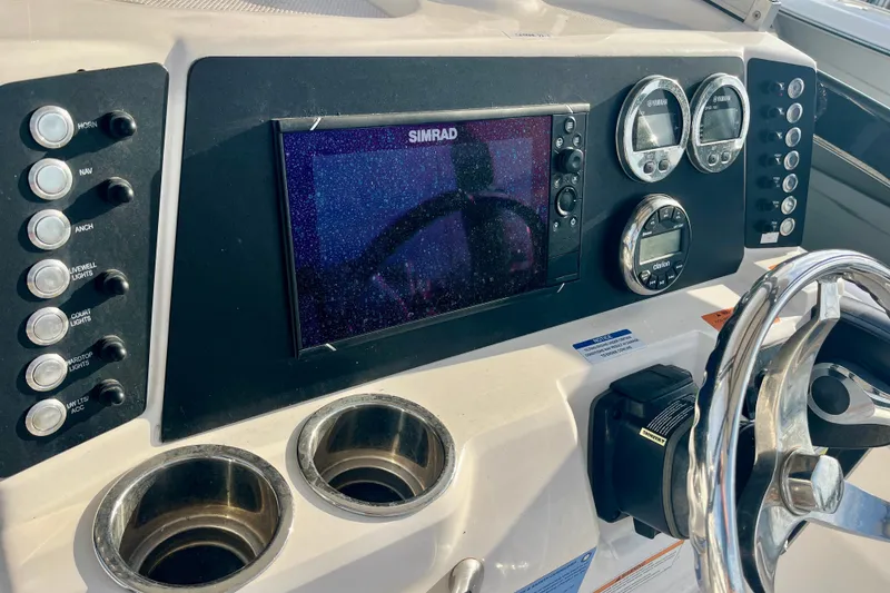 Slide: The Image of 2025 Robalo 226 Cayman dashboard with Simrad display and control panel. - 9