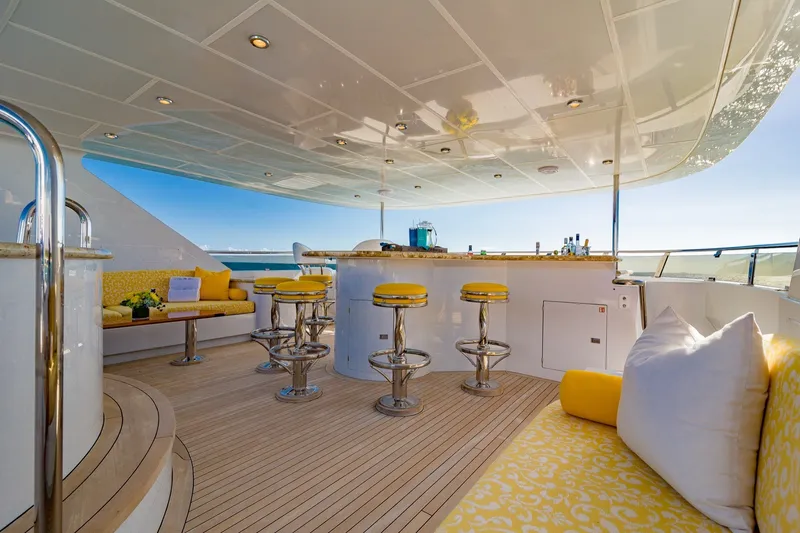 Slide: The Image of Luxurious 2002 Christensen Trideck yacht deck with bar, yellow seating, and ocean view. - 46
