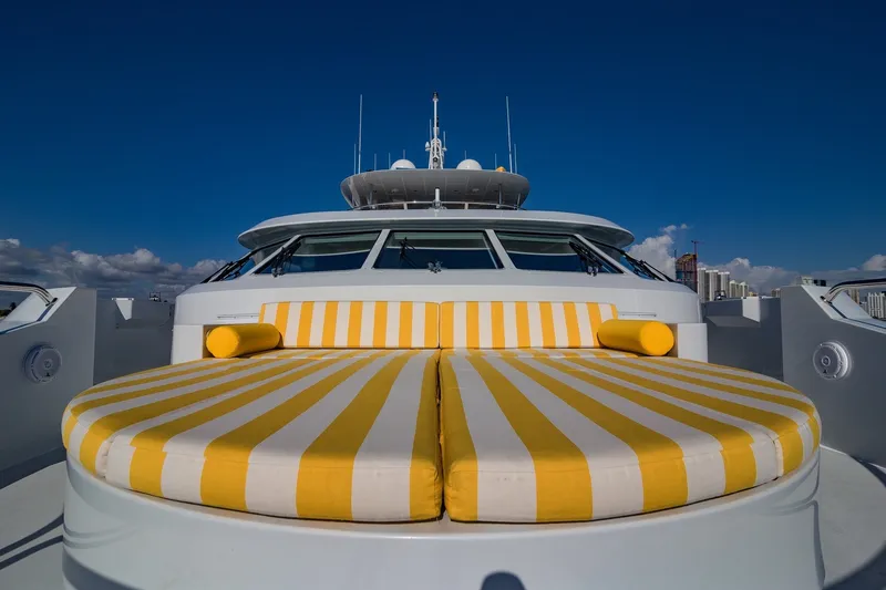 Slide: The Image of Luxurious 2002 Christensen Trideck yacht with striped yellow sunbeds under a clear blue sky. - 43