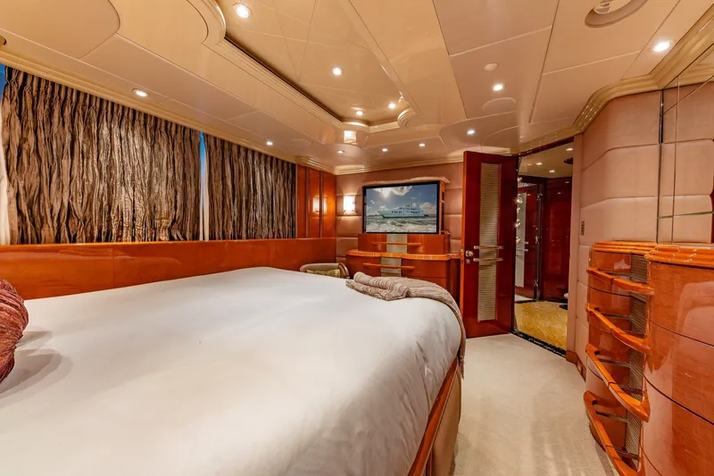 Slide: The Image of Luxurious bedroom interior on 2002 Christensen Trideck yacht, featuring elegant wood finishes and ambient lighting. - 24