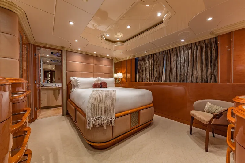 Slide: The Image of Luxurious bedroom interior on 2002 Christensen Trideck yacht, featuring elegant wood finishes. - 23
