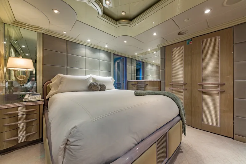 Slide: The Image of Luxurious bedroom interior on 2002 Christensen Trideck yacht, featuring elegant decor and plush bedding. - 27