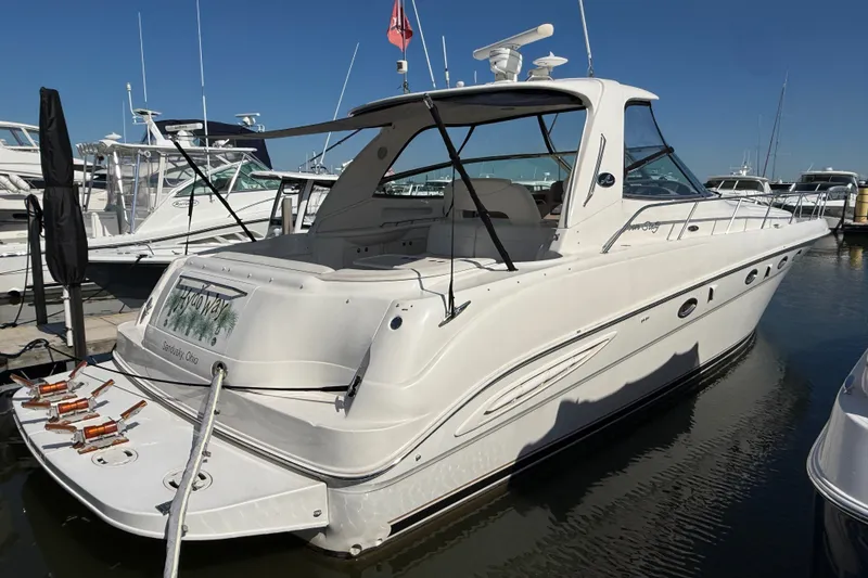The Image of 2002 Sea Ray Sundancer 460 yacht docked at marina under clear blue sky. - 0