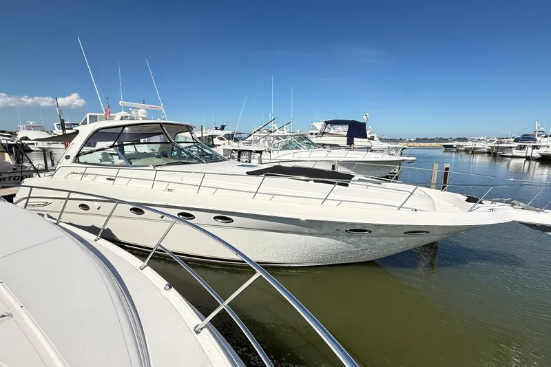 Slide: The Image of 2002 Sea Ray Sundancer 460 yacht docked in a marina under clear blue skies. - 7