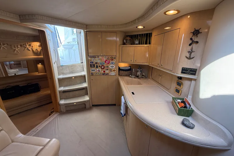 Slide: The Image of Interior of 2002 Sea Ray Sundancer 460 yacht, featuring a cozy kitchen and elegant wood cabinetry. - 75