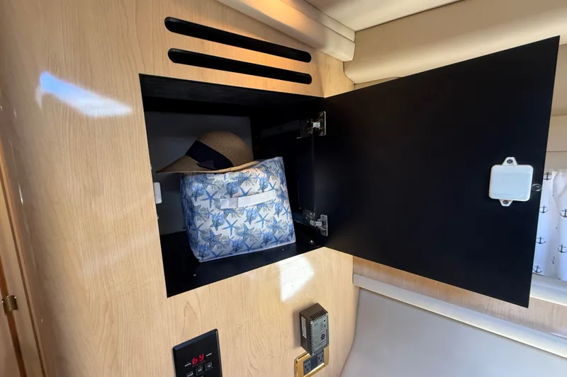 Slide: The Image of Open cabinet in 2002 Sea Ray Sundancer 460 yacht with hat and starfish-patterned bag. - 56