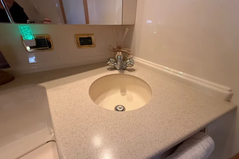 Slide: The Image of Bathroom sink area in 2002 Sea Ray Sundancer 460 yacht, featuring beige countertop and chrome faucet. - 60