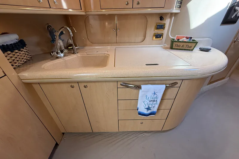 Slide: The Image of 2002 Sea Ray Sundancer 460 yacht kitchen with sink, cabinets, and decorative towel. - 42
