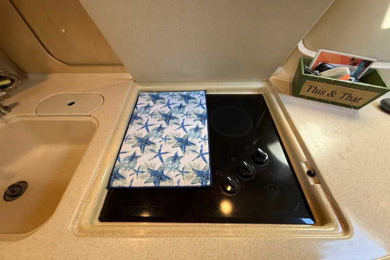 Slide: The Image of Kitchen area of a 2002 Sea Ray Sundancer 460 yacht with stove and decorative towel. - 45