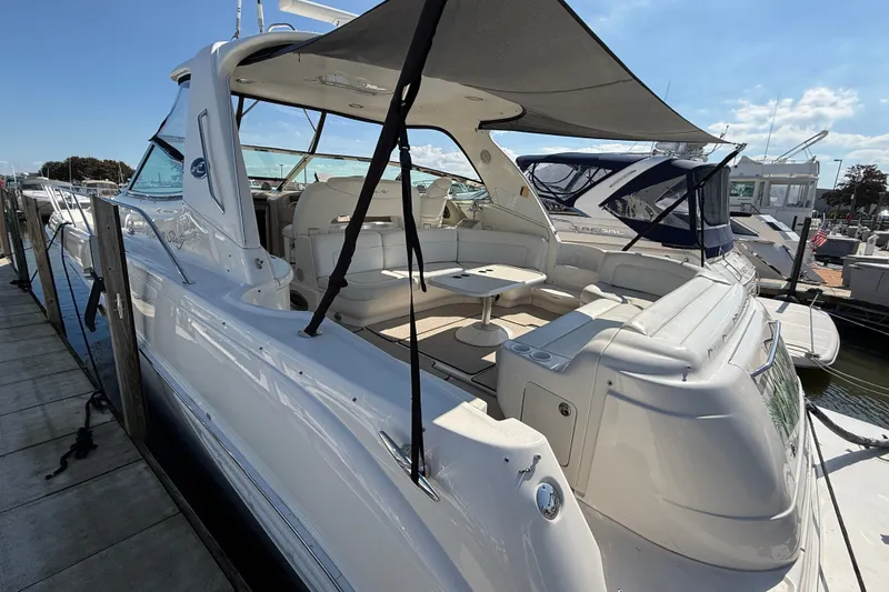 Slide: The Image of 2002 Sea Ray Sundancer 460 yacht docked, featuring spacious seating and sunshade. - 2