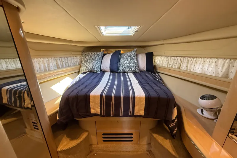 Slide: The Image of Cozy bedroom interior of 2002 Sea Ray Sundancer 460 yacht with striped bedding. - 51