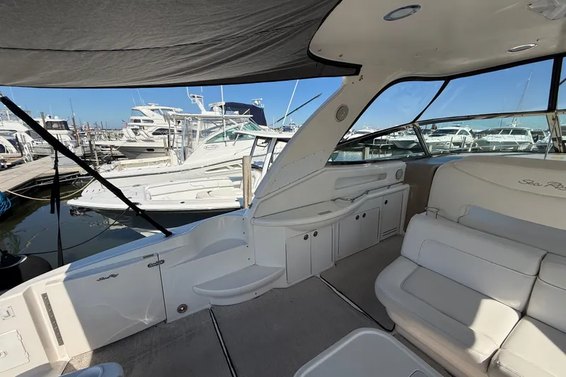 Slide: The Image of 2002 Sea Ray Sundancer 460 yacht interior at marina, showcasing seating and cabinetry. - 20