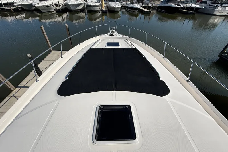Slide: The Image of 2002 Sea Ray Sundancer 460 yacht docked at marina, showcasing sleek deck design. - 9